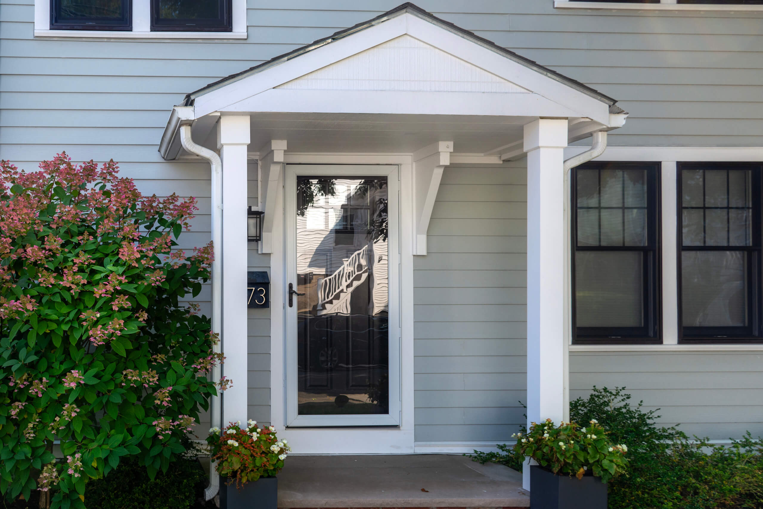 White storm door on a teal house.